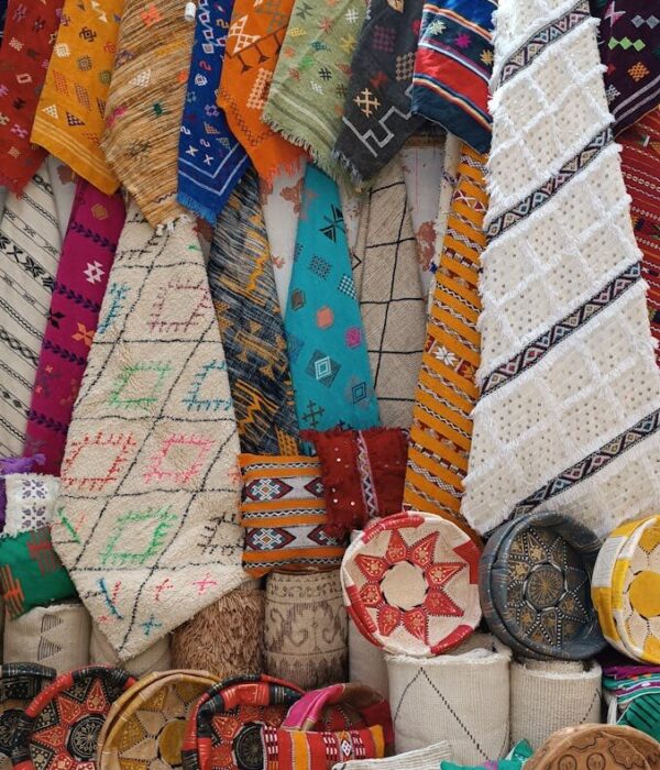 Vibrant Moroccan rugs and cushions on display, showcasing intricate designs and craftsmanship.