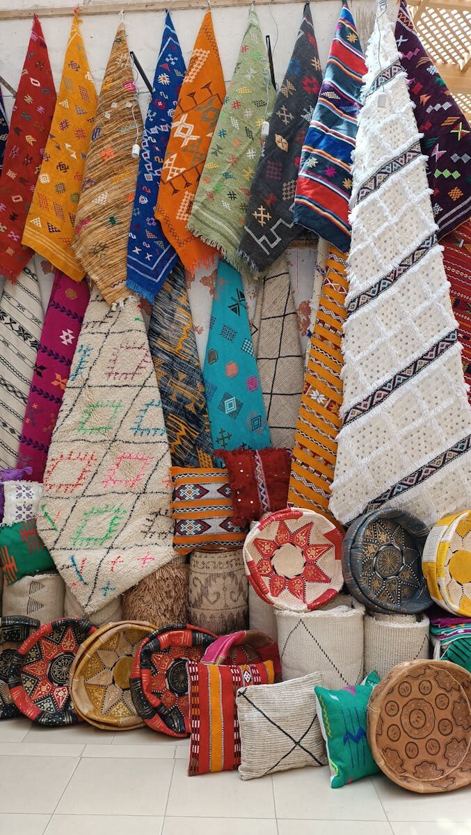 Vibrant Moroccan rugs and cushions on display, showcasing intricate designs and craftsmanship.