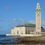 Stunning view of the Hassan II Mosque in Casablanca by the Atlantic coast under a clear blue sky.